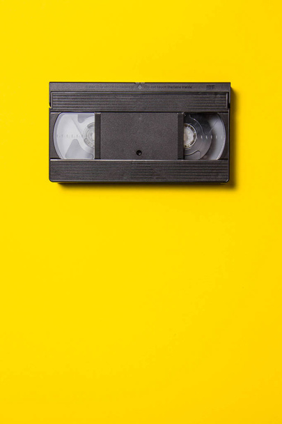 Black classic video tape on a yellow background - Zdjęcie, obraz