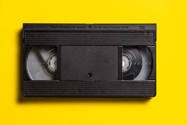 Black classic video tape on a yellow background - Valokuva, kuva