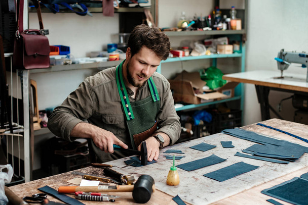 Un maître travaille avec du cuir véritable dans l'atelier
 - Photo, image