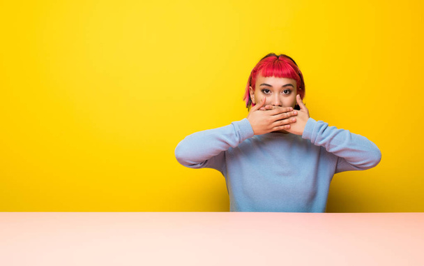 Jonge vrouw met roze haren die betrekking hebben op mond met handen - Foto, afbeelding