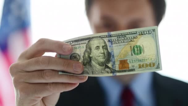 Amerykański biznesmen posiadający 100 dolara, zbliżenie męskiej osoby biznesowej - Materiał filmowy, wideo