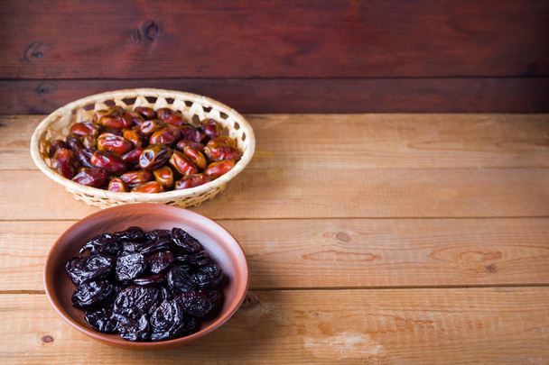 Dried dates and prunes on wooden background. Holy month of Ramadan, concept. Righteous Muslim lifestyle. Starvation. Dried fruits: dates, prunes and raisins on wooden boards - Valokuva, kuva