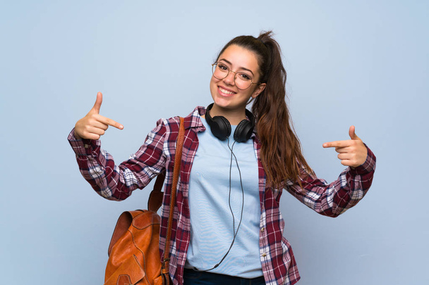 Teenager studentessa oltre isolato muro blu orgoglioso e soddisfatto di sé
 - Foto, immagini