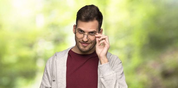 Mann mit Sweatshirt und Brille im Park überrascht - Foto, Bild