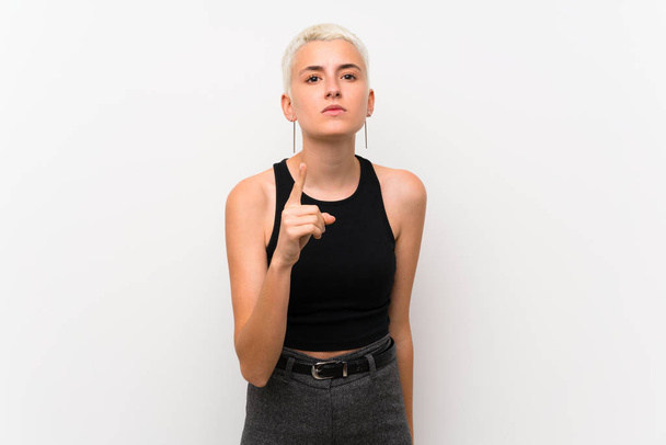 Teenager girl with short hair over white wall frustrated and pointing to the front - Fotoğraf, Görsel