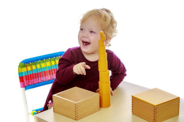 A kislány az asztalnál dolgozik a Montessori anyag. - Fotó, kép