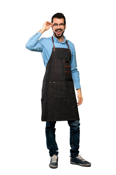 Full-length shot of Man with apron with glasses and surprised over isolated white background - Foto, Imagem