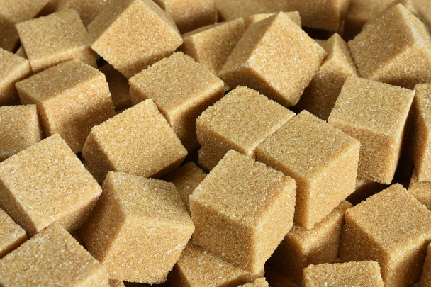 Крупный план нескольких кубиков коричневого сахара
.  - Фото, изображение