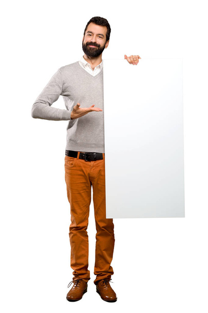 Feliz hombre guapo con barba sosteniendo un cartel vacío
 - Foto, imagen