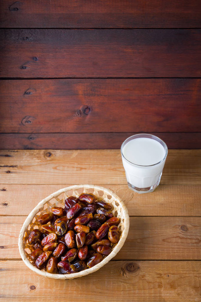 Dried dates and milk on wooden background. Holy month of Ramadan, concept. Righteous Muslim lifestyle. Starvation. Dates in a wooden basket in the style of minimalism. Copy space - Foto, Imagem