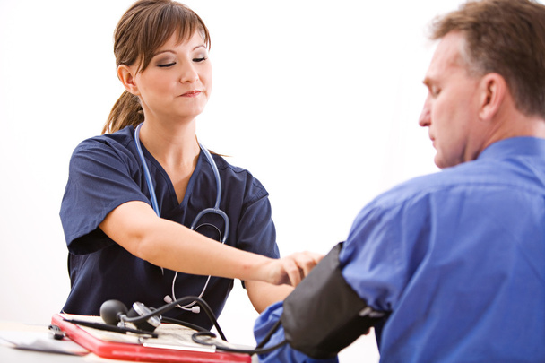 Doctors: Removing Blood Pressure Cuff - Valokuva, kuva