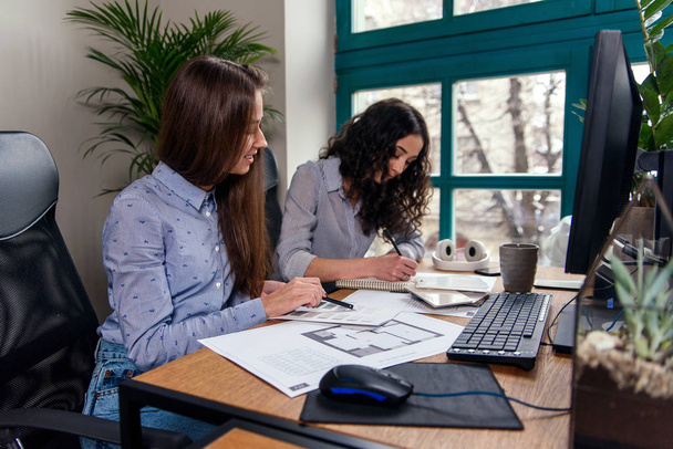 Handsome women architects in blue shirts working with color palatte to choose design and colors on the office background. - Foto, Imagen