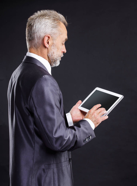 serious businessman looking at digital tablet screen - Fotó, kép