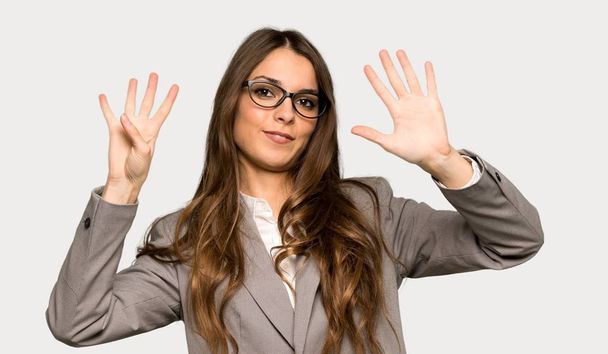 Business woman counting nine with fingers over isolated grey background - Foto, imagen
