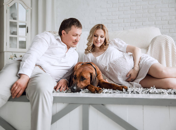 happy young couple with their pet sitting on the floor in their new apartment. - Foto, Bild