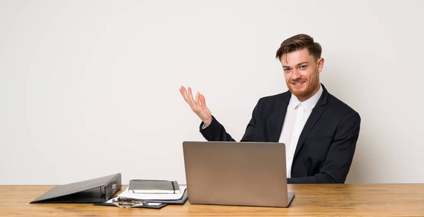 Businessman in a office extending hands to the side for inviting to come - Фото, зображення