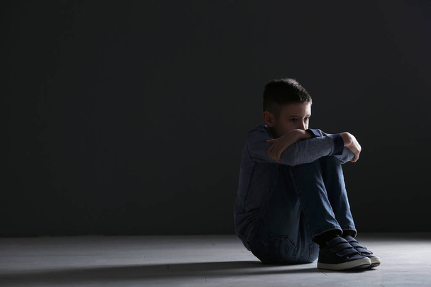 Upset boy sitting in dark room. Space for text - Foto, immagini