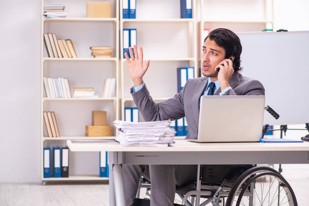 Joven empleado guapo en silla de ruedas en la oficina
  - Foto, Imagen