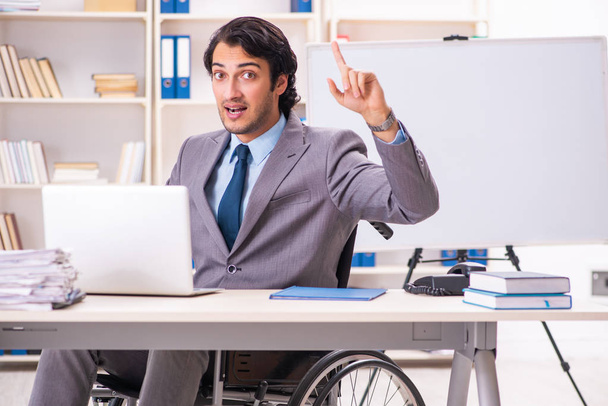 Jeune beau employé en fauteuil roulant au bureau
  - Photo, image