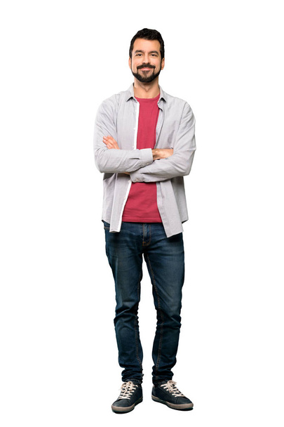 Full-length shot of Handsome man with beard keeping the arms crossed in frontal position over isolated white background - Foto, immagini