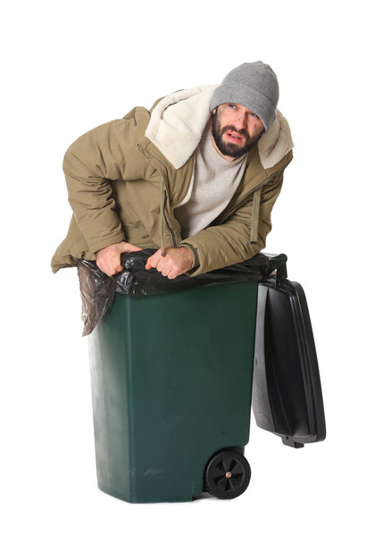 Бідний безпритульний чоловік у сміттєвому баку ізольований на білому
 - Фото, зображення