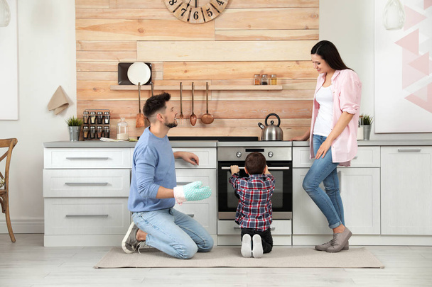 Happy family baking food in oven at home - Foto, imagen