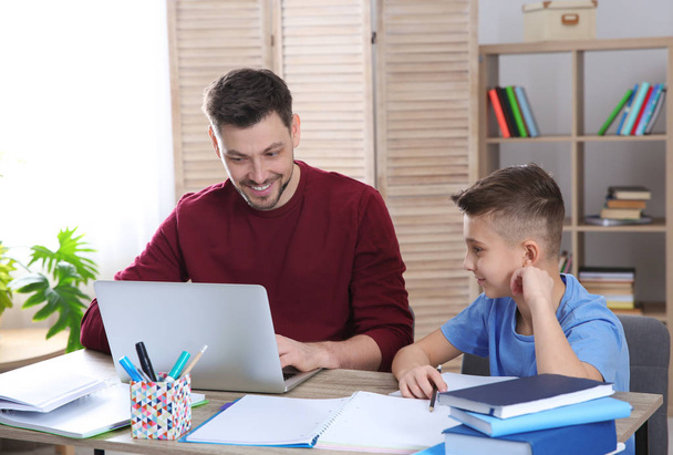 Dad helping his son with homework in room - Foto, Imagen