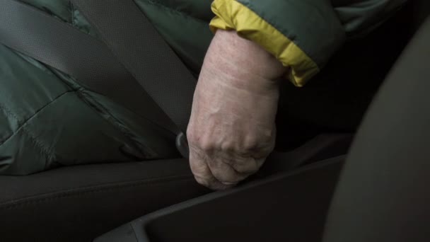 Mulher mais velha prende um cinto de segurança em um carro - Close up shot of her hand
 - Filmagem, Vídeo