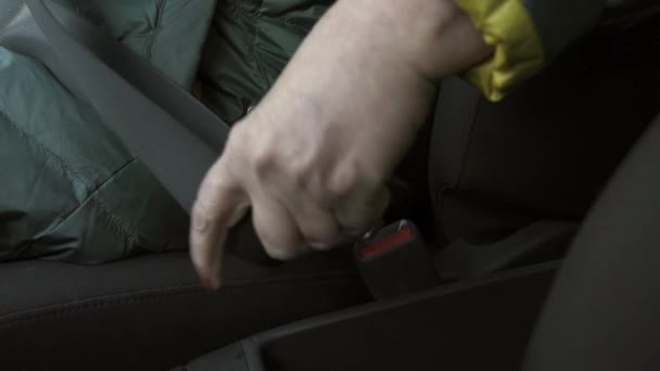 La femme plus âgée attache une ceinture de sécurité dans une voiture-fermez le projectile de sa main - Séquence, vidéo