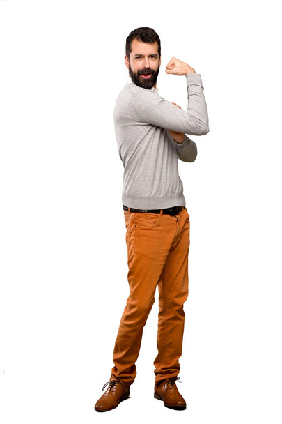 Knappe man doet sterk gebaar over geïsoleerde witte achtergrond - Foto, afbeelding