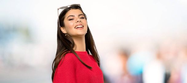 Ragazza adolescente con maglione rosso Felice e sorridente all'aperto
 - Foto, immagini