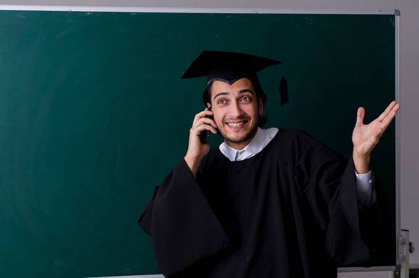 Yüksek lisans öğrencisi yeşil panonun önünde.  - Fotoğraf, Görsel