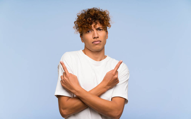 Fiatal afro-amerikai férfi fehér ingben, aki a laterálisokra mutat, kétségei vannak. - Fotó, kép