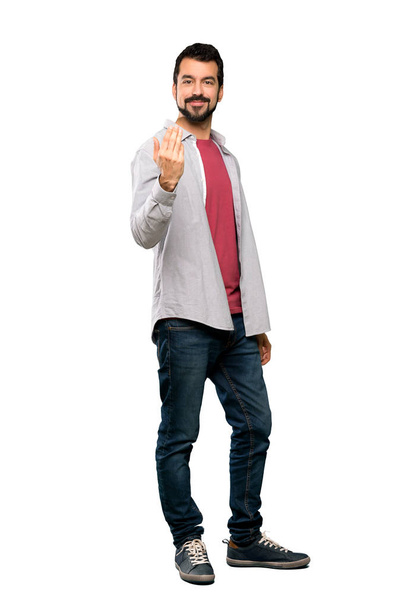 Full-length shot of Handsome man with beard inviting to come with hand. Happy that you came over isolated white background - Foto, Bild