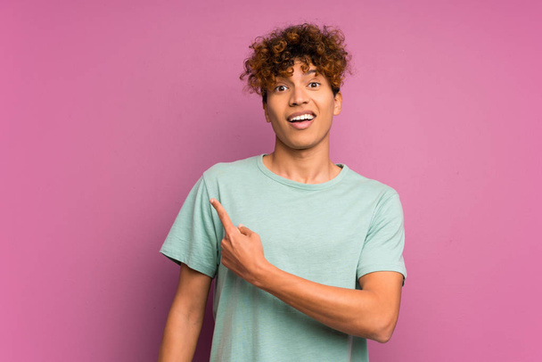 Joven afroamericano hombre sobre aislado púrpura pared señalando el dedo a un lado
 - Foto, imagen