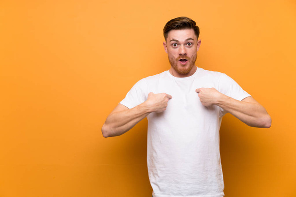 Redhead man over brown wall with surprise facial expression - Photo, Image