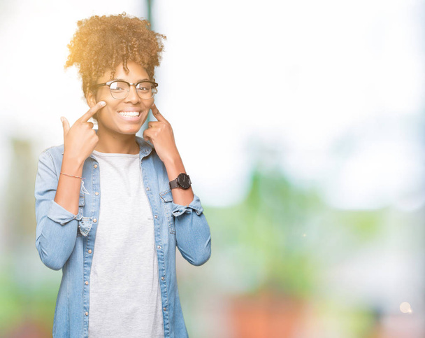Güzel genç Afro-Amerikan kadın gözlük izole üzerinde gülen arka plan açık ağız ile parmak işaret ve neşeli gülümseme zorlamadan - Fotoğraf, Görsel