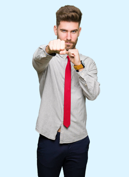 Young handsome business man Punching fist to fight, aggressive and angry attack, threat and violence - Foto, immagini