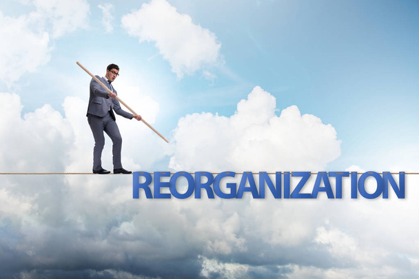 Reorganisation concept with businessman walking on tight rope - Photo, Image