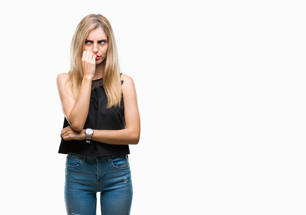 Young beautiful blonde and blue eyes woman over isolated background looking stressed and nervous with hands on mouth biting nails. Anxiety problem. - Photo, Image