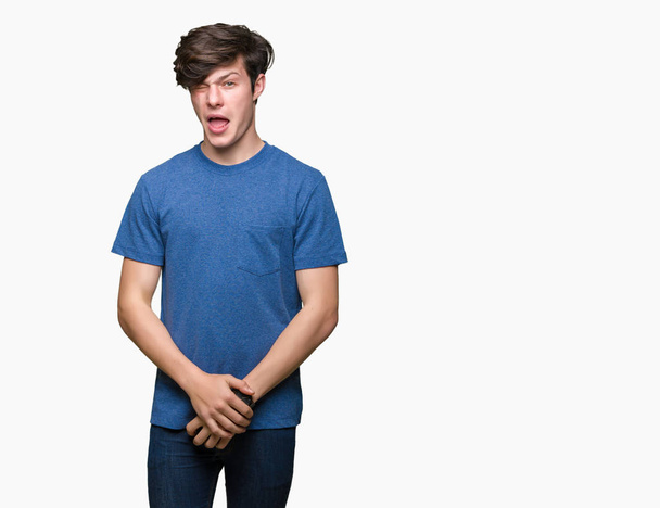 Молодий красивий чоловік у синій футболці над ізольованим тлом підморгує дивлячись на камеру з сексуальним виразом, веселим і щасливим обличчям
. - Фото, зображення