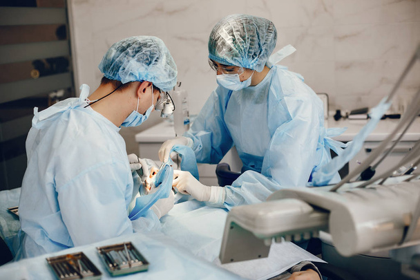 Dos dintistas trabajando con un paciente
 - Foto, imagen