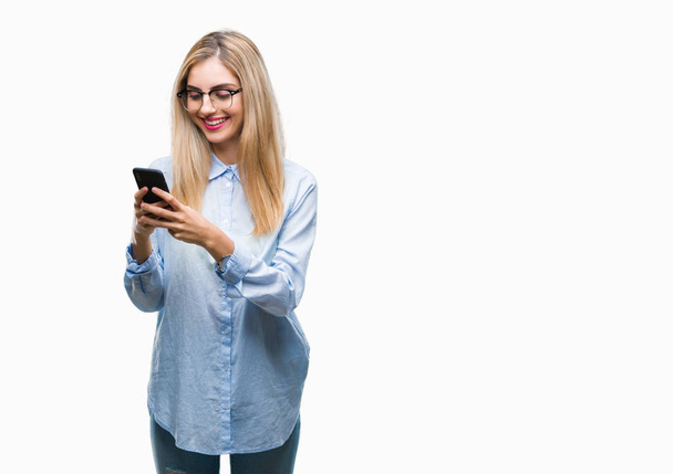 Young beautiful blonde business woman using smartphone over isolated background with a happy face standing and smiling with a confident smile showing teeth - Fotoğraf, Görsel