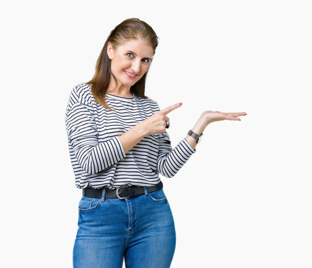 Średnim wieku Starsza kobieta piękne swetrze zima paski na na białym tle tło wyświetlone dłoni ręki i robi ok gest z kciuki w górę, uśmiechający się wesoły i pogodny - Zdjęcie, obraz
