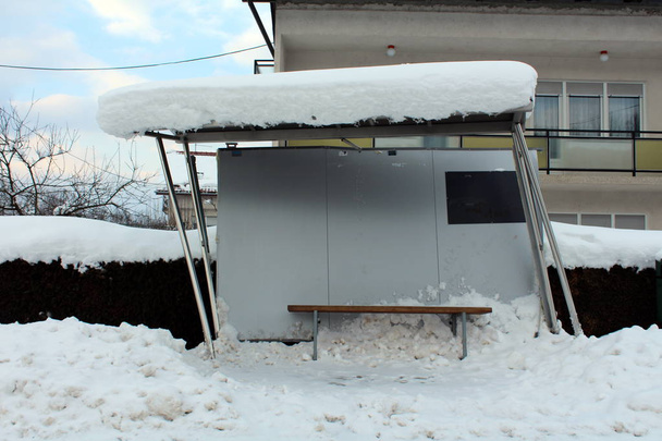 完全に覆われ、雪に囲ま冬の間にクラッシュした後に左に傾いた inox、金属板とガラスから作られる壊れたバスステーション - 写真・画像