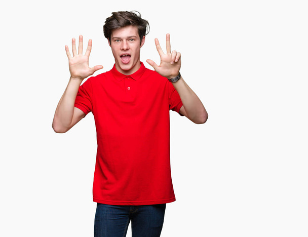 junger gutaussehender Mann, der ein rotes T-Shirt über isoliertem Hintergrund trägt und mit Finger Nummer acht nach oben zeigt, während er selbstbewusst und glücklich lächelt. - Foto, Bild