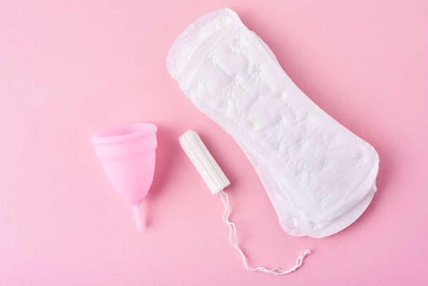Sanitaire pad, menstruatiecup en tampon op een roze achtergrond - Foto, afbeelding