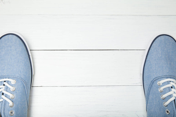 Soft comfortable blue sneakers on a white wooden background, emp - Fotó, kép