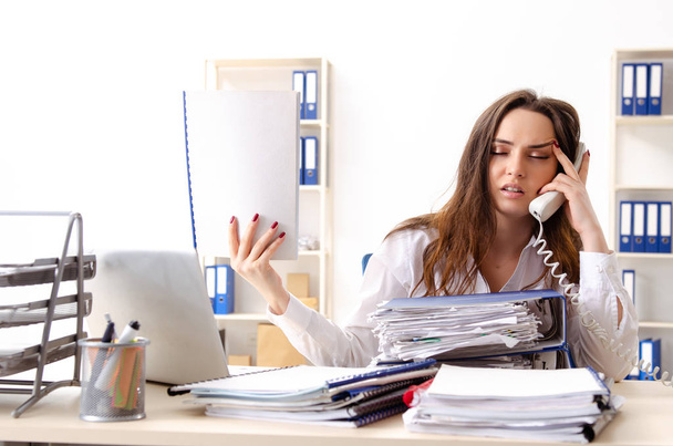 Jovem funcionária infeliz com excesso de trabalho
  - Foto, Imagem
