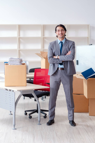 Молодой человек с коробками в офисе
  - Фото, изображение